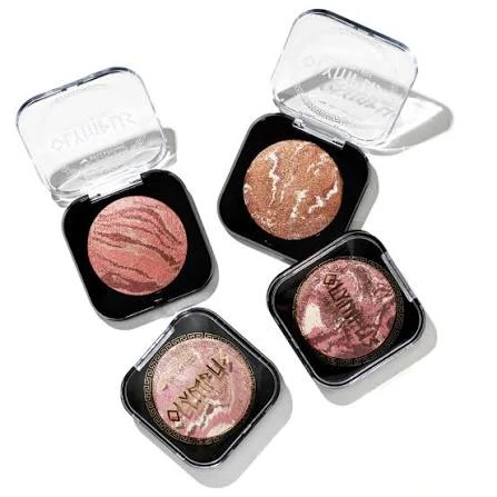 Paleta com três tons de blush liquido em embalagens compactas quadradas, com acabamento cintilante rosado e bronze, sobre fundo branco