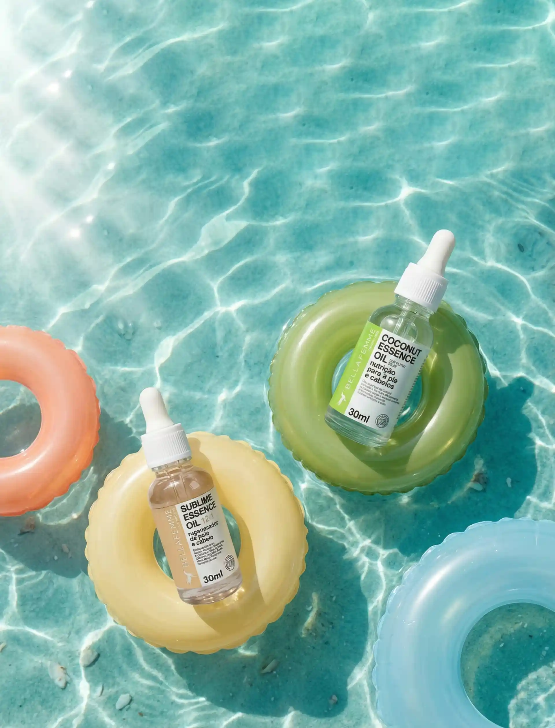 Óleos capilares de coco e sublime essência, ambientados em boias infláveis no estilo beach vacation, representando cuidados de skin care com a pele e cabelo durante o verão.