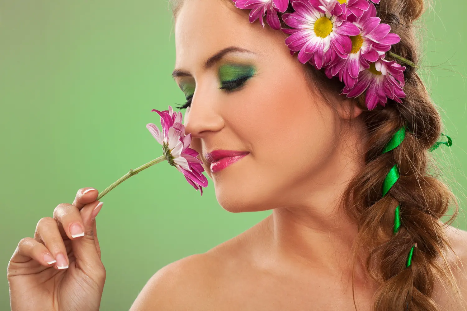 mulher toda produzida com maquiagem de primavera cheirando uma flor rosa