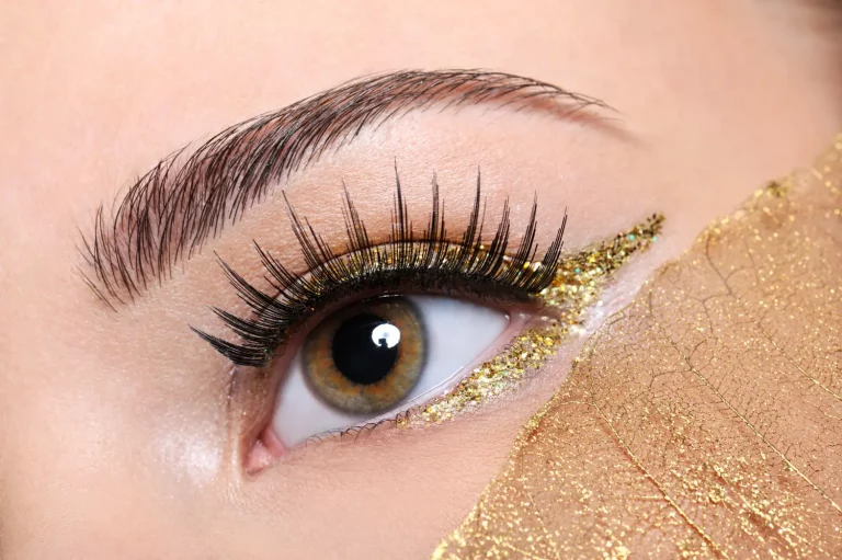 Modelo maquiada com delineado com glitter dourado
