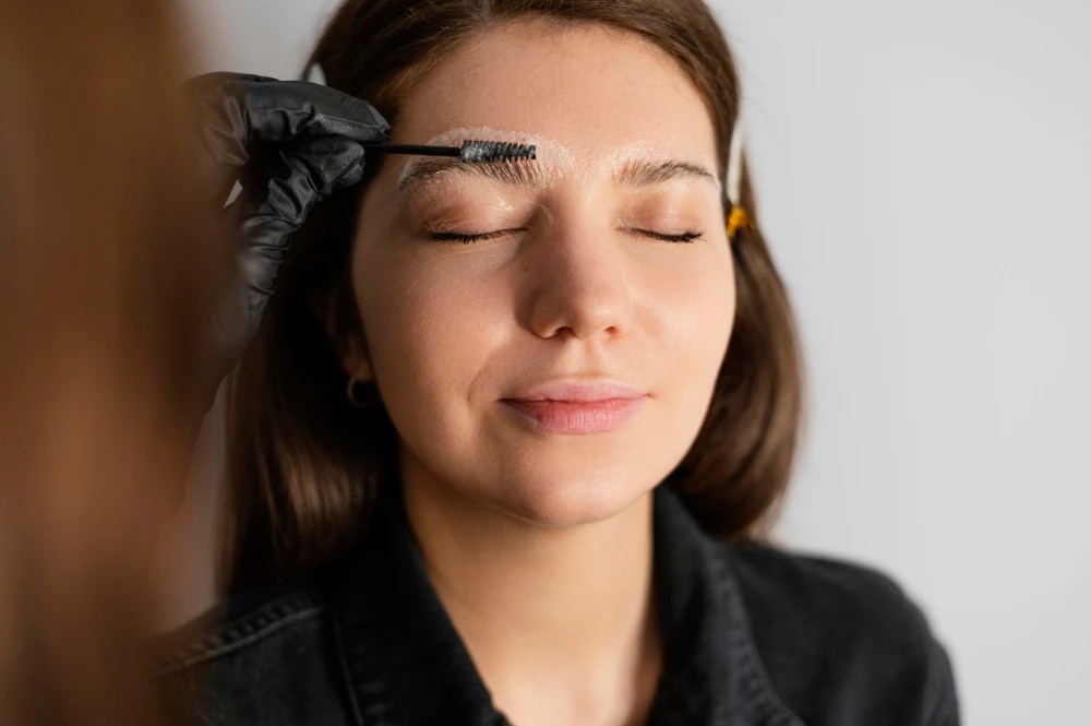 Mulher com expressão de satisfação após aplicação de gel para sobrancelha, cuidando da beleza do olhar.