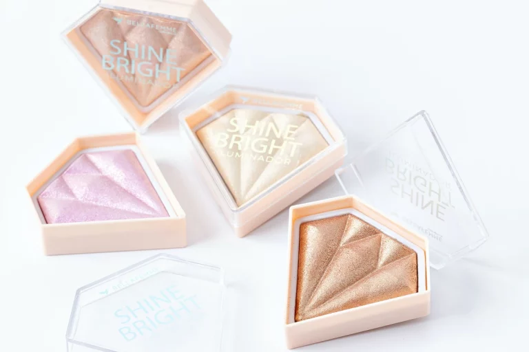 Produtos de maquiagem iluminadores da linha Shine Bright da Bella Femme com embalagens em forma de diamante em diferentes tonalidades.