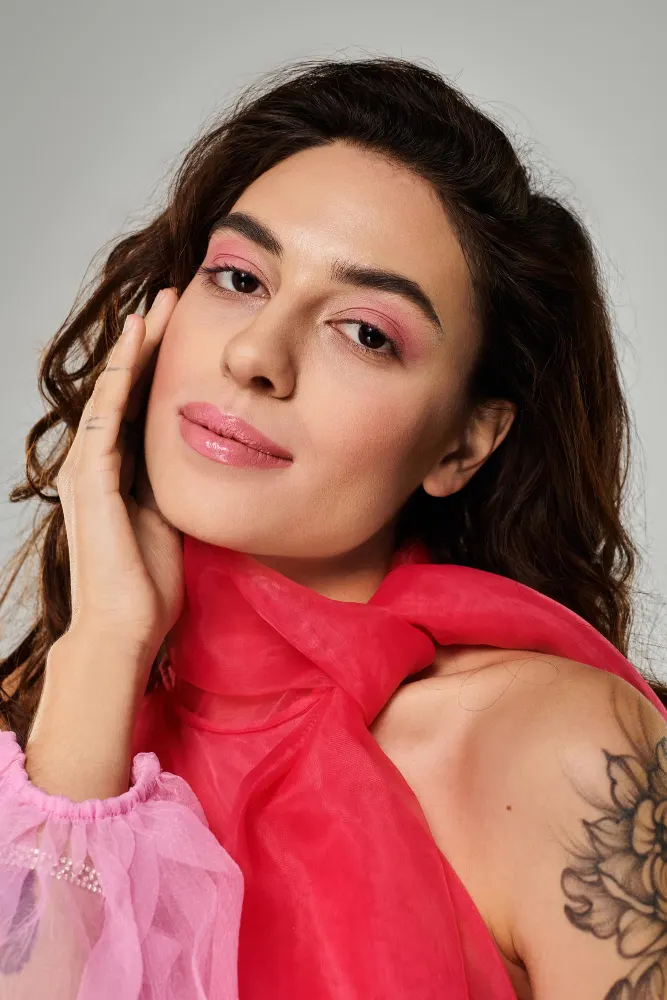 Maquiagem romântica para o dia dos namorados: mulher com delineado suave, sombras rosadas e batom nude-rosado, usando lenço vermelho e pose de close
