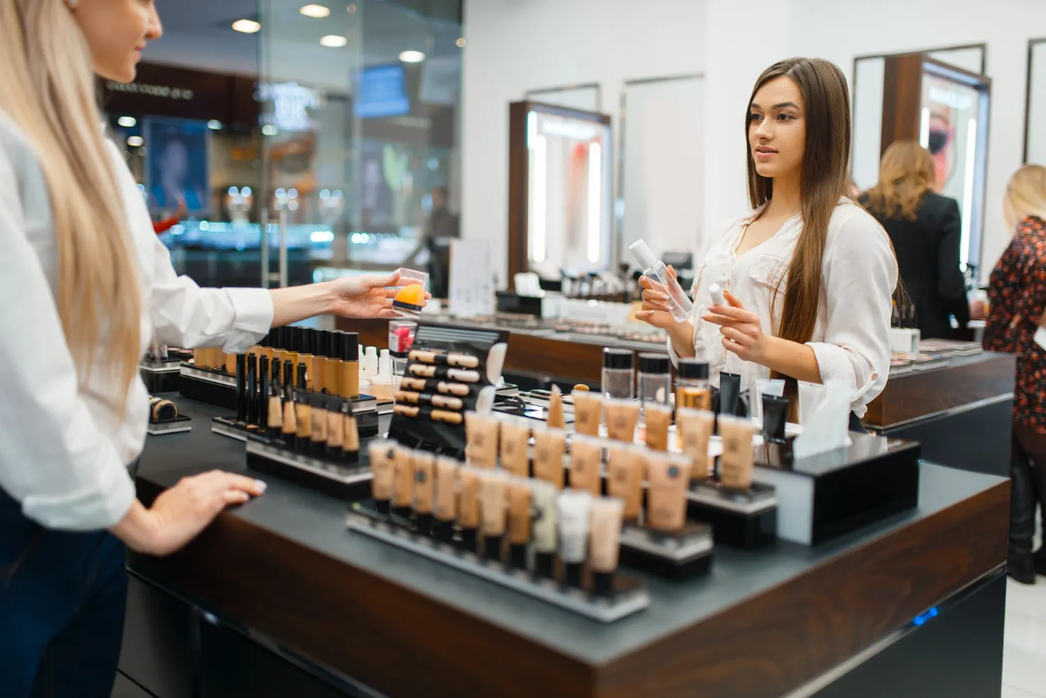 Atendimento em uma loja de cosméticos no dia do cliente, com vendedora oferecendo amostras e pessoa escolhendo produtos em uma bancada organizada com maquiagem e embalagens.