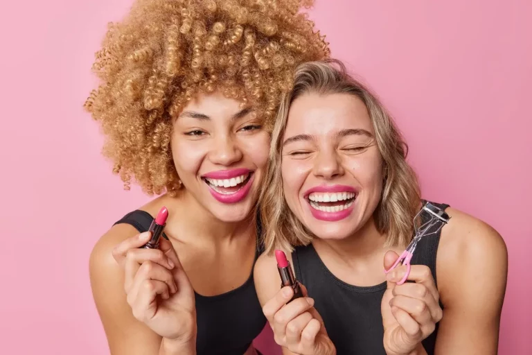 Mulheres sorrindo segurando maquiagens