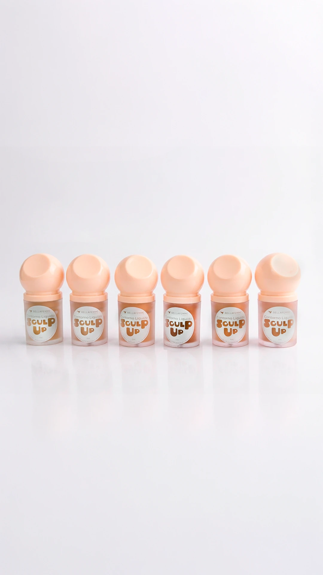 Maquiagem para o rosto Bella Femme: seis frascos do Contorno Líquido Sculpt Up em tons de bege e tampa arredondada, dispostos em linha sobre fundo claro.