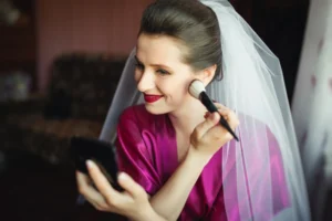 Noiva com vestido rosa claro aplicando maquiagem para noiva com maquiagem de blush e maquiagem para casamento