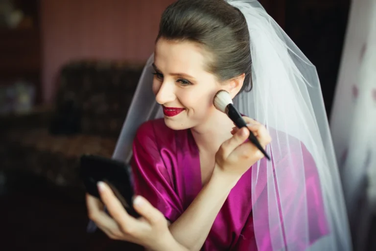 Noiva com vestido rosa claro aplicando maquiagem para noiva com maquiagem de blush e maquiagem para casamento
